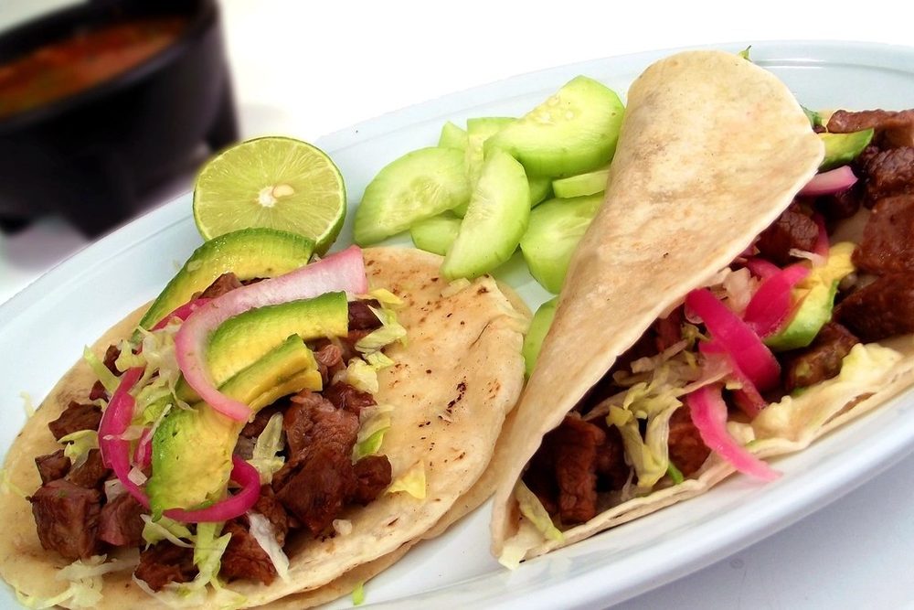 Tacos piled with pickled onion and avocado